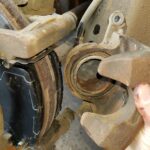 Install the caliper over the new brake pads.