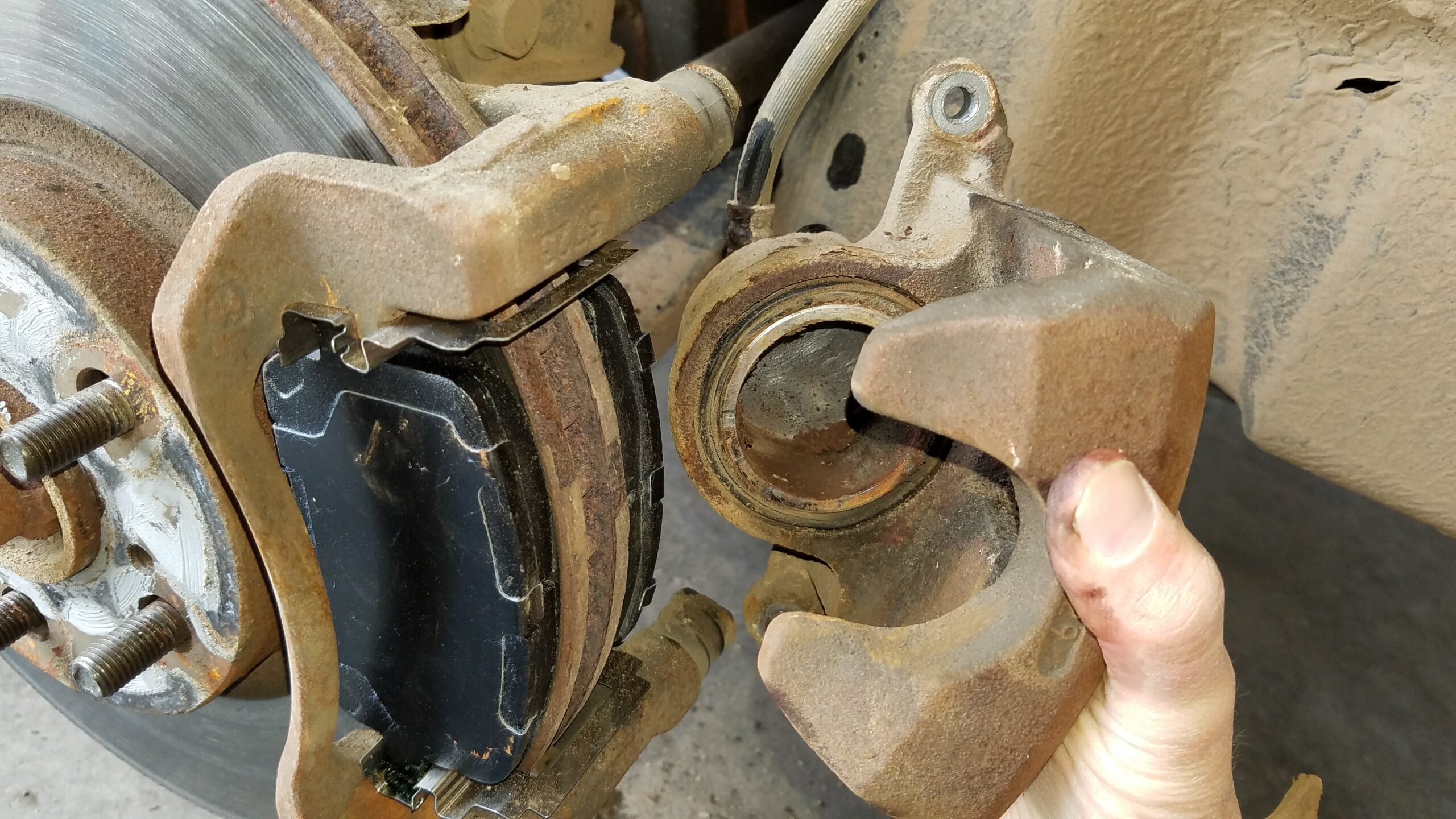 Install the caliper over the new brake pads.