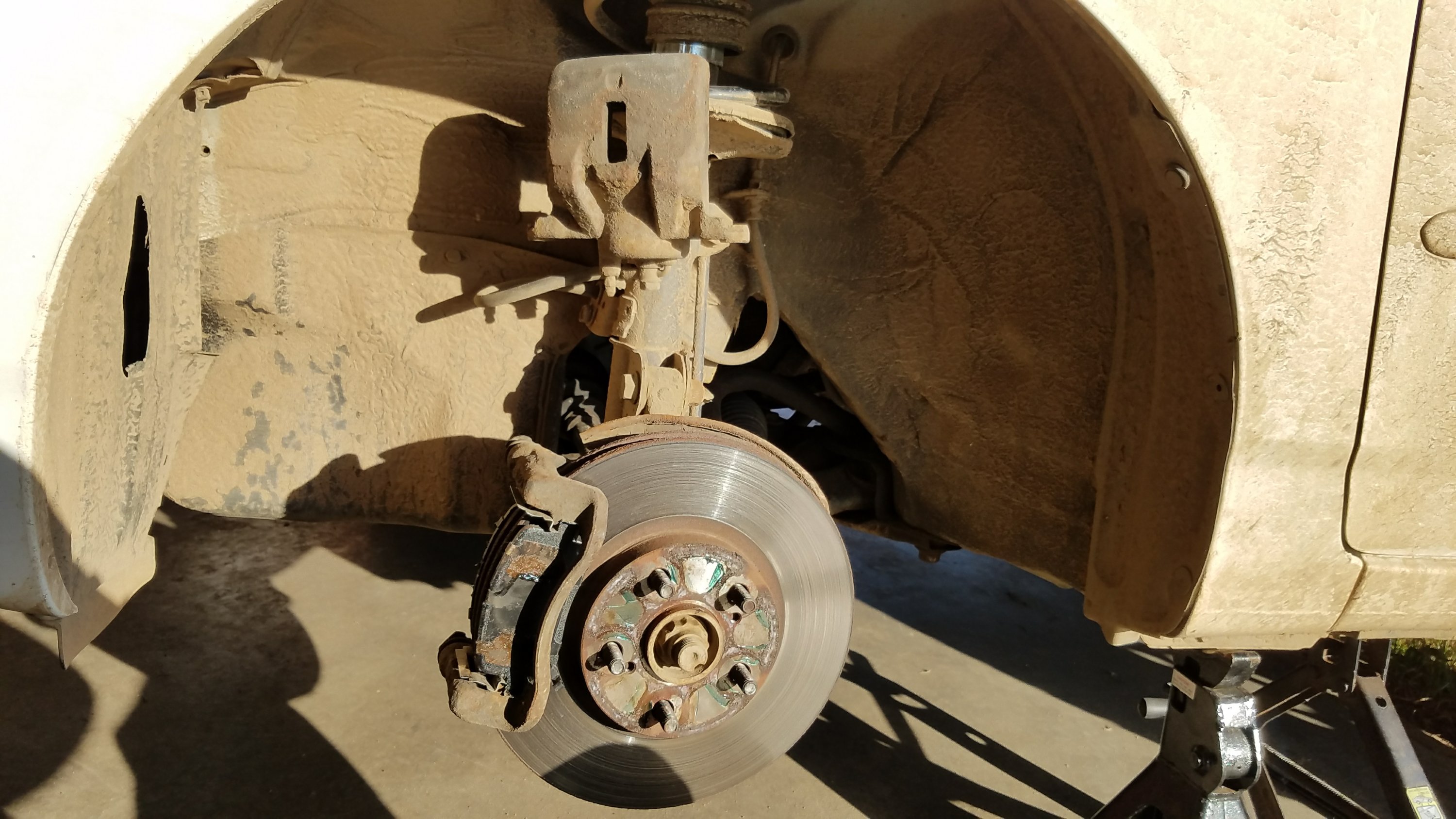 Wheel and caliper removed from a toyota corolla.