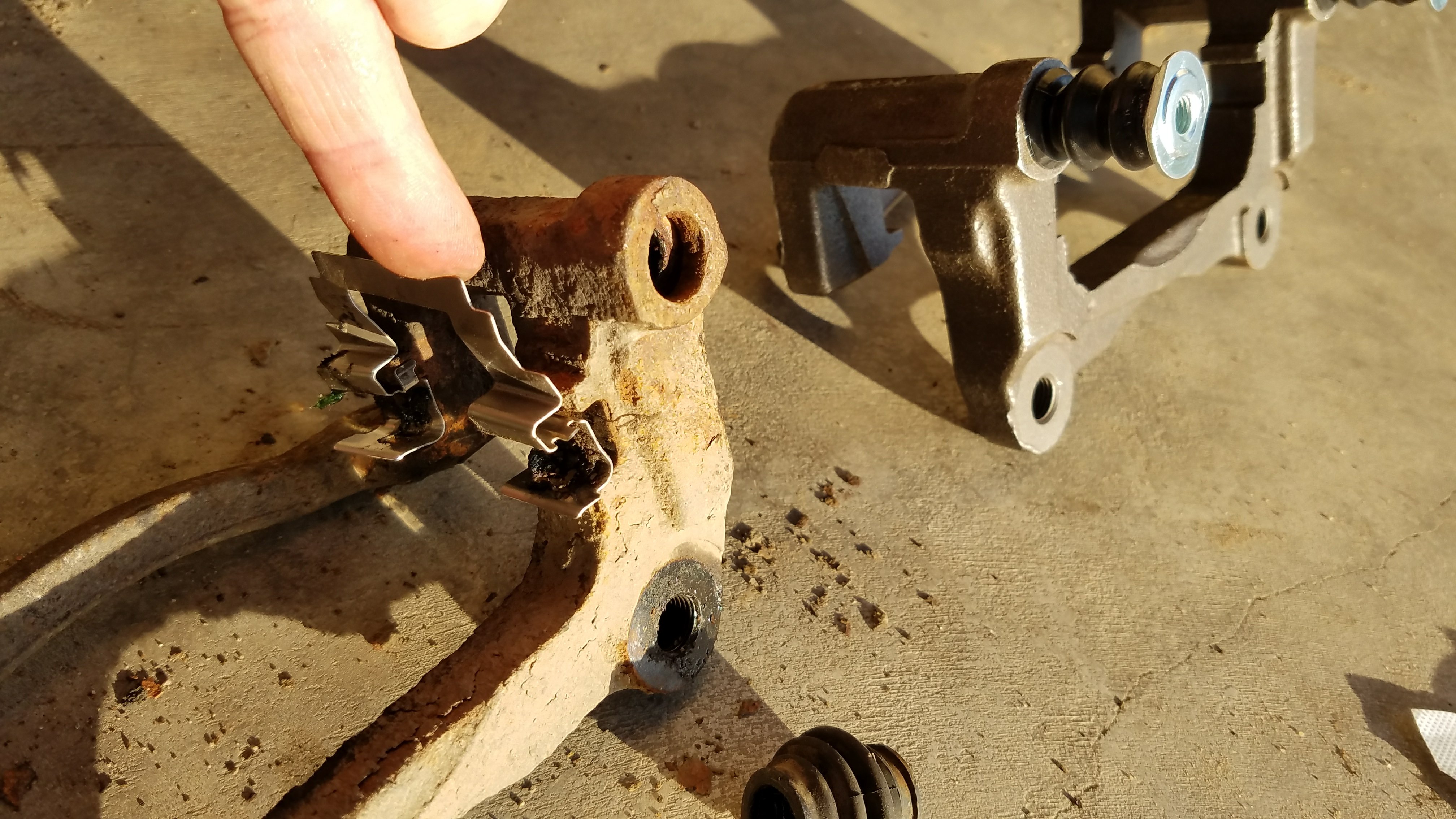 Remove slide tabs from old caliper bracket.