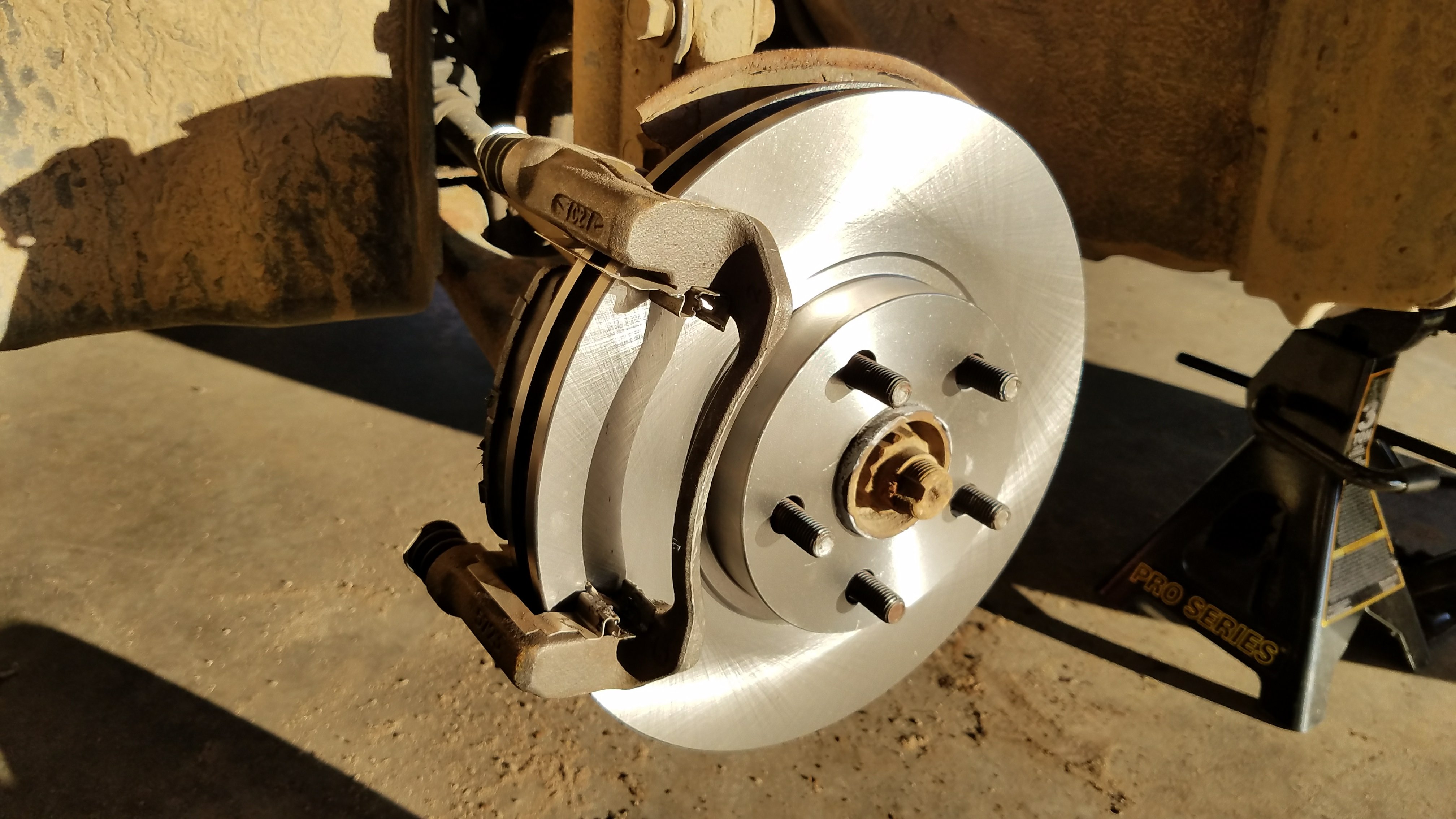 Caliper bracket correctly installed over the rotor on a corolla