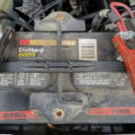 A car battery with jumper cables attached.