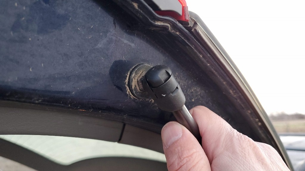 Pressing the strut onto the connection point. No need to pull back the clip, it should just snap in place.